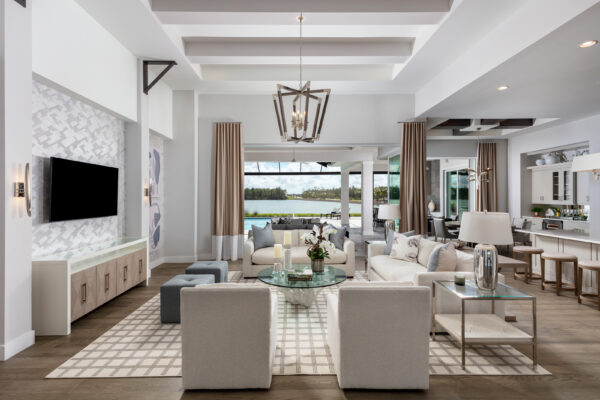 Lifestyle shot of an expansive open-concept great room in a Caymas Naples home, floor-to-ceiling glass doors opening to a luxurious lanai and pool at golden hour, premium furnishings, warm neutral tones, 8K photorealistic, ultra-detailed