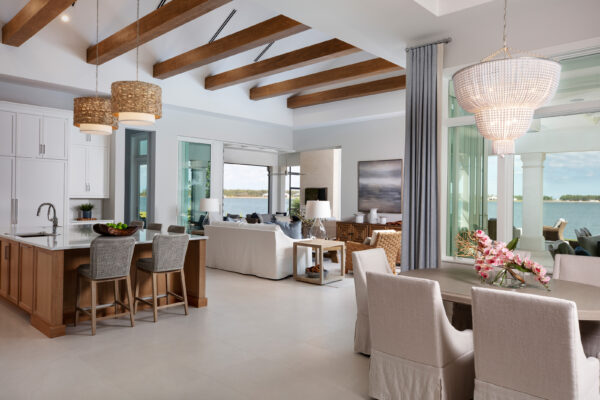 Cozy reading nook inside a Caymas Naples custom home featuring built-in shelving, premium upholstery, warm lighting, and large windows with views of the lanai, photorealistic 8K detail