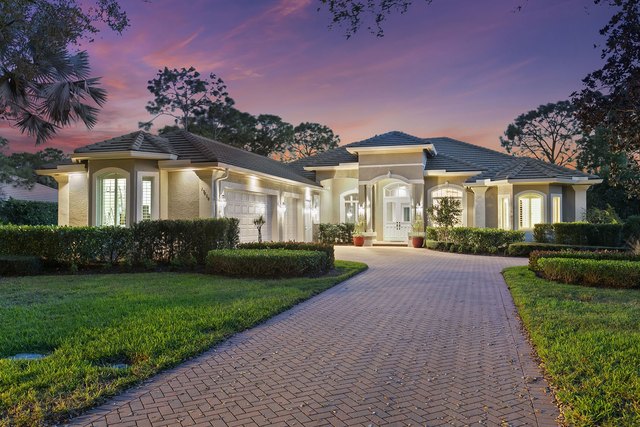 Alternative angle of a luxury waterfront home within Collier's Reserve with private dock, overlooking the preserve and golf course, golden morning light, photorealistic 8K luxury real estate photography
