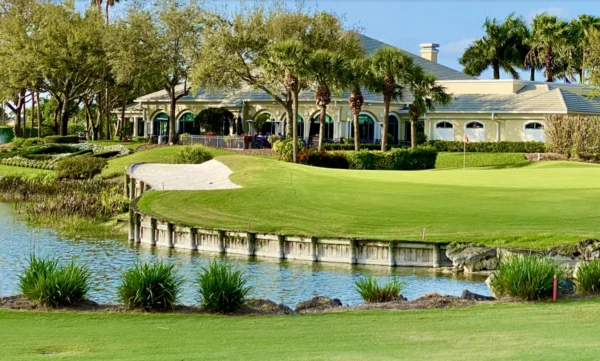 Lifestyle photorealistic 8K image of a distinguished couple in elegant golf attire walking off the 18th green at Cypress Woods Golf & Country Club in Naples Florida at golden hour, lush fairways lined with tall cypress trees, Mediterranean clubhouse visible in background, warm natural light, high-end lifestyle photography