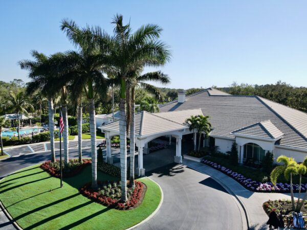 Photorealistic 8K aerial view of the pristine Cypress Woods Golf & Country Club 18-hole championship course in Naples FL, winding through dense cypress woods with manicured fairways, strategic bunkers, and sparkling water hazards, bright Florida sunshine, premium real estate photography