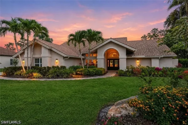 Photorealistic 8K lifestyle shot of the gated entrance to Oaks of Estero luxury community at golden hour, showing the private entrance with lush landscaping and massive mature oak trees lining the street, elegant signage, luxury homes visible in soft background, warm natural light, sense of exclusivity and tranquility, highly detailed, National Geographic style