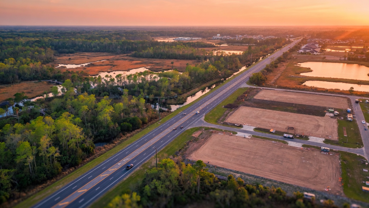Aerial view of Corkscrew Road corridor looking east through Florida preserve land and future residential development pads in Estero, golden hour lighting, photorealistic 8K