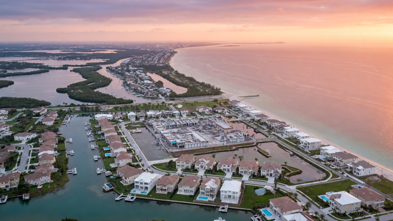 Sunrise aerial view of Bonita Springs Florida coastline showing new construction communities, waterways, and proximity to Gulf of Mexico with beautiful atmospheric lighting