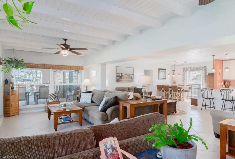 Living room with plenty of natural light, beamed ceiling, and light tile floors