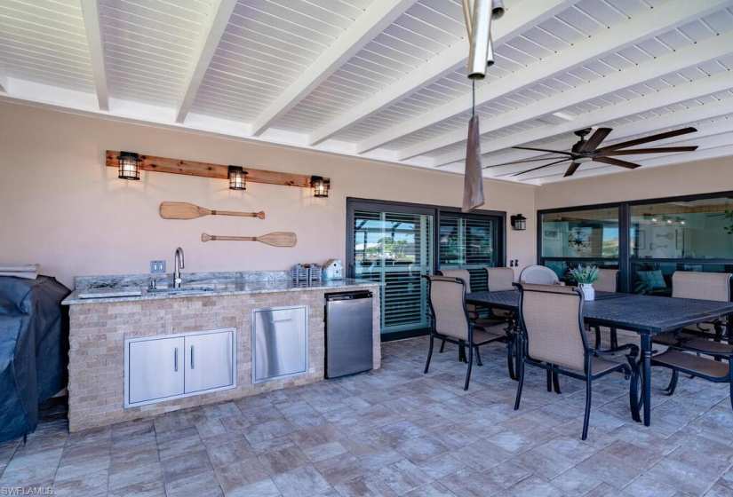 View of patio featuring ceiling fan, sink, and area for grilling