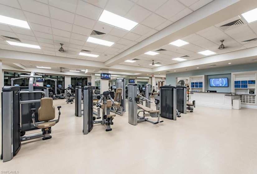 Gym with ceiling fan and a drop ceiling