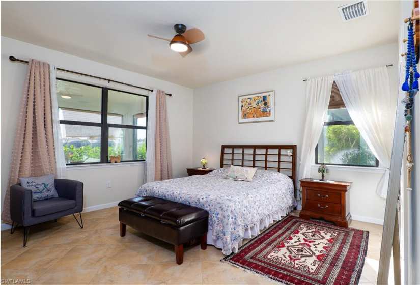 Bedroom featuring tile flooring, multiple windows, and ceiling fan