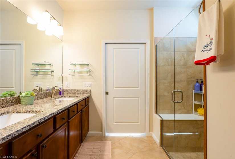 Bathroom with tile flooring, dual sinks, and vanity with extensive cabinet space
