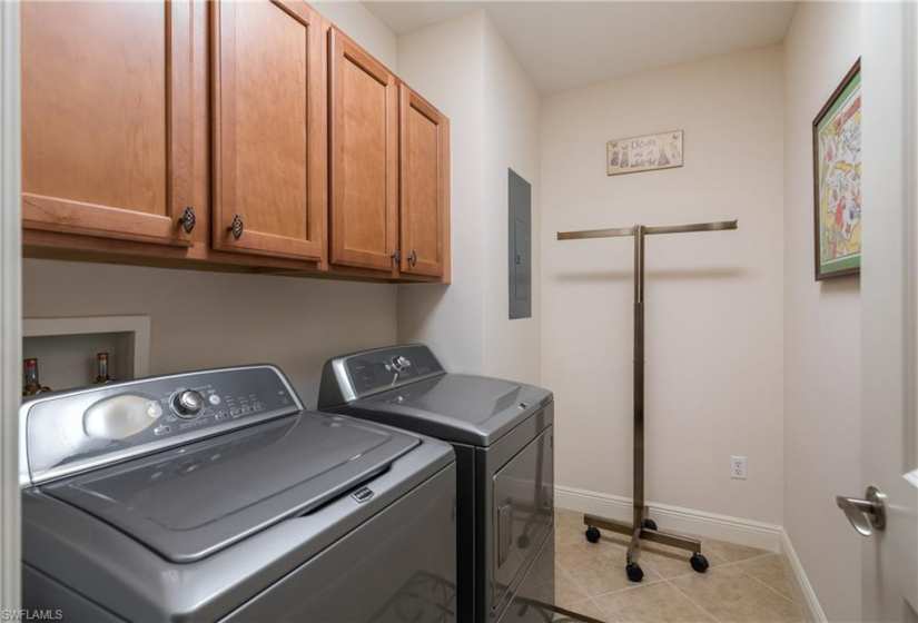 Laundry room with washer and dryer, cabinets, hookup for a washing machine, and light tile floors