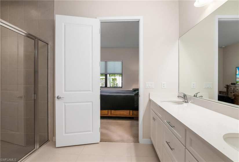 Bathroom with tile floors, walk in shower, large vanity, and double sink