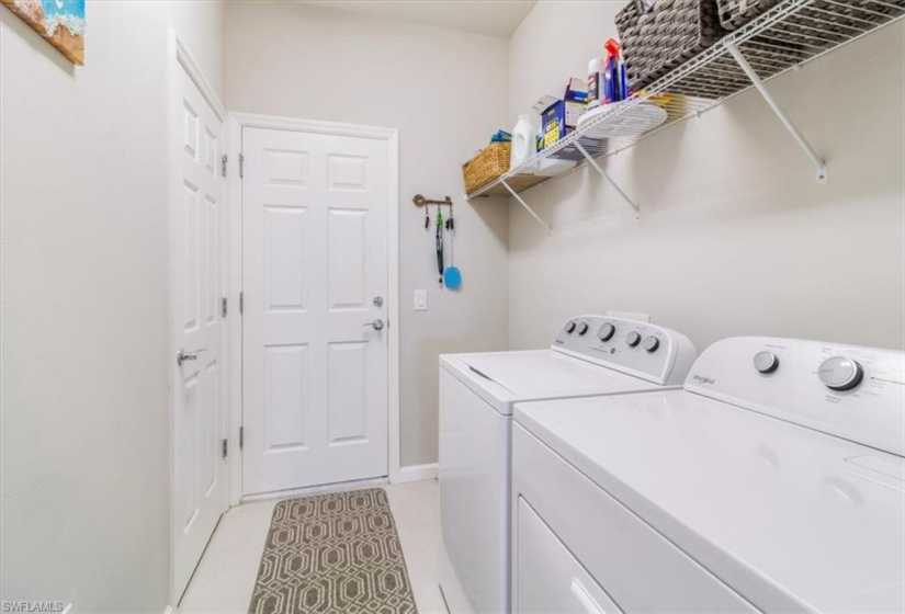 Washroom featuring washer and dryer and light tile flooring