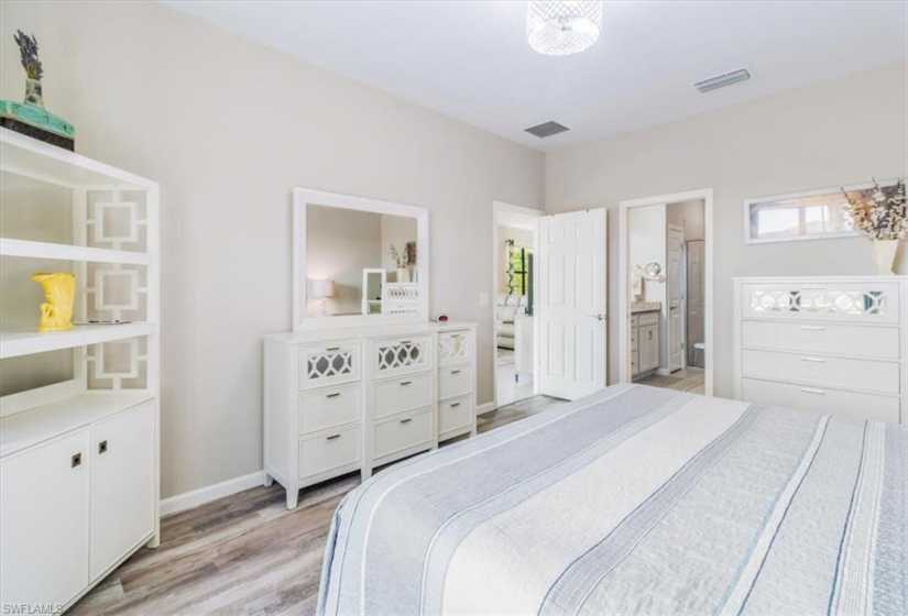 Bedroom with ensuite bathroom and light wood-type flooring