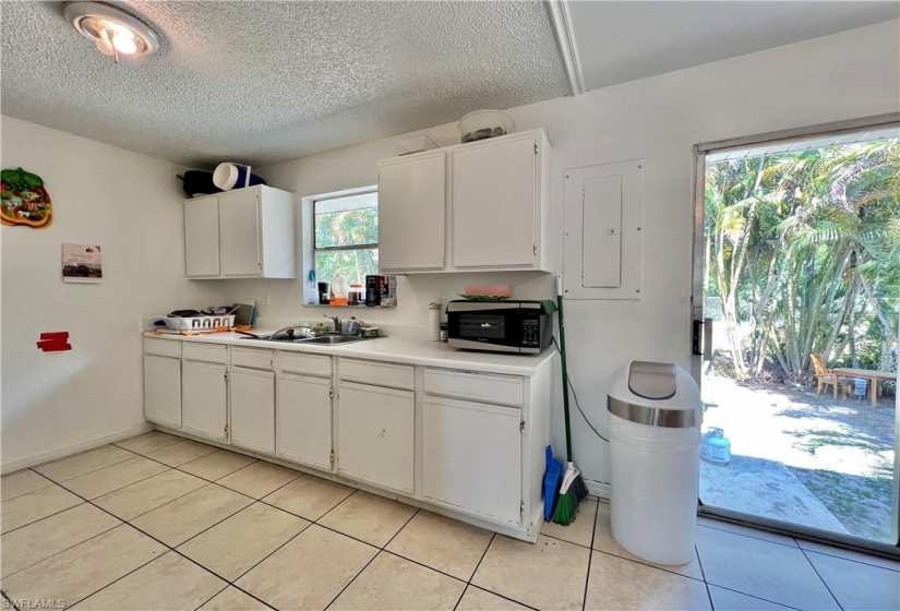 Kitchen featuring white cabinets, sink, and light tile floors