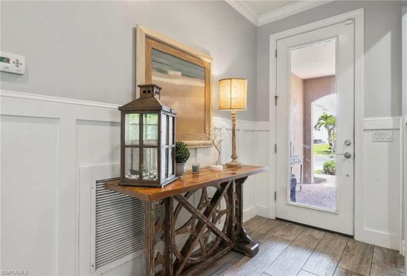 What a beautiful light and bright entrance door!  Also, look at the nice elevated baseboard decoration.