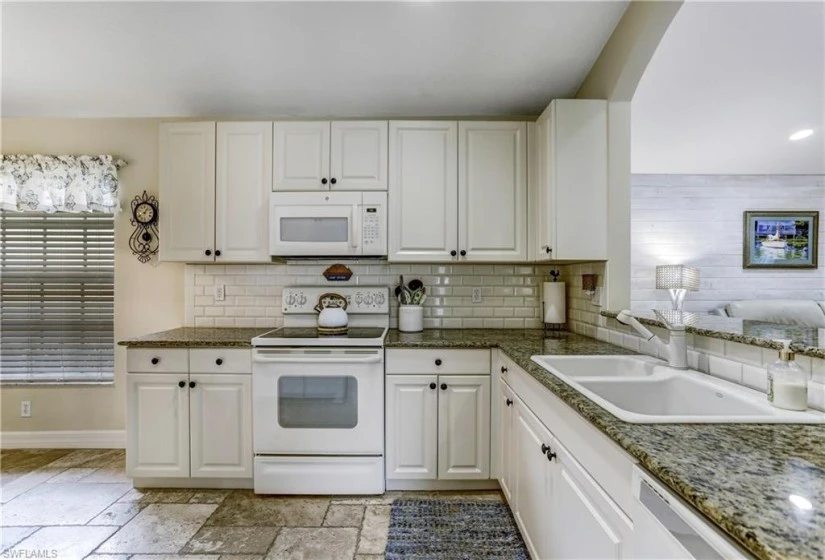 White cabinetry, subway tile, granite counters.