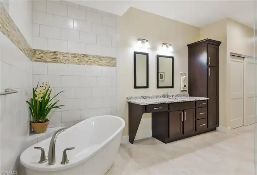 Gorgeous primary bathroom with walk-in shower and frameless glass enclosure and freestanding soaking tub!