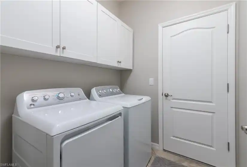 Additional cabinets over the washer and dryer provide ample storage.