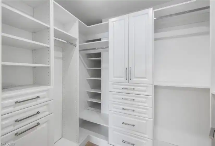 Primary bedroom walk-in closet with built-in closet system.