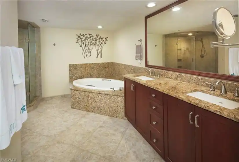 Primary en suite bathroom with dual sinks, walk in shower and soaking tub.