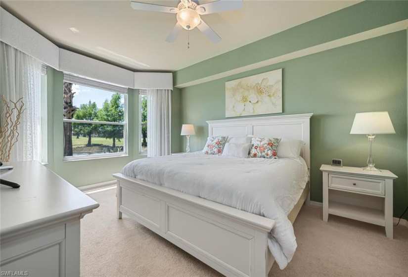 Peaceful primary bedroom with abundant daylight and lake/golf views
