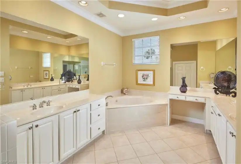 Primary en suite bathroom with separate sink/vanity areas, a walk in shower and a soaking tub.