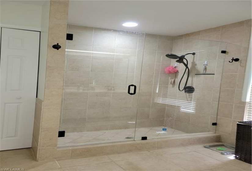 Walk-in shower with glass door in master bathroom