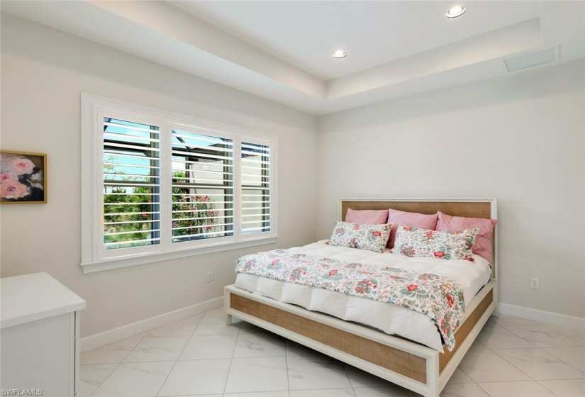 Serene views from the primary suite. Tray ceilings, plantation shutters and ensuite bath.